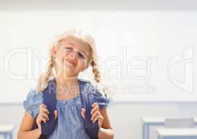 Young girl happy with bag in classroom