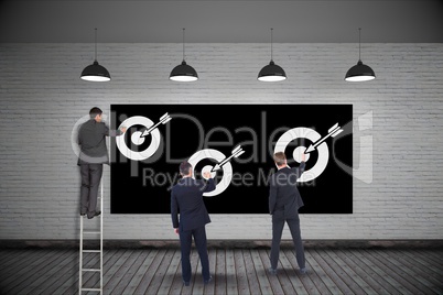 Businessmen setting targets on wall