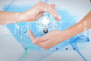 Digitally generated image of hand holding electric bulb