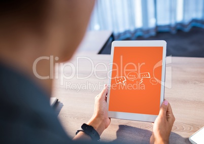 Person at desk with tablet showing white speech bubble graphics against orange background
