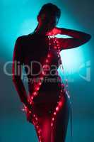 Sensual woman with red fairy lights over blue glowing background