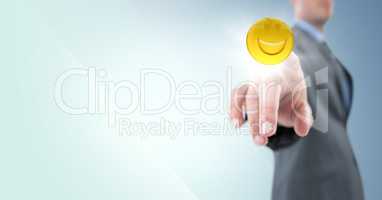 Business man pointing at emoji with flare against blue background