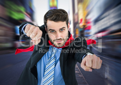 Business man superhero with hands out against blurry street