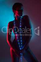 Sensual woman in lingerie with colorful fairy lights over blue and red glowing background