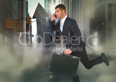 Business man on phone with briefcase running across arrow shaped road in street with flares