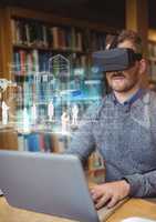 Man in library on laptop wearing VR Virtual Reality Headset with Interface