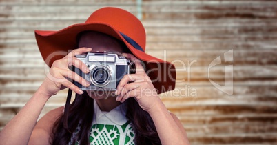 Close up of woman with camera against blurry wood panel