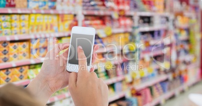 Cropped image of hand using smart phone in store