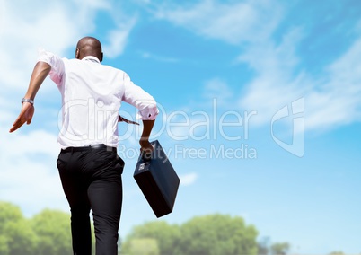 Businessman running with briefcase with sky