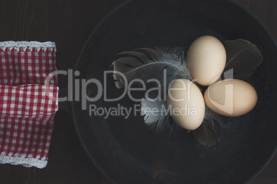 Chicken eggs in a black cast-iron frying pan