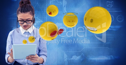Digitally generated image of woman using tablet computer with emojis flying against tech graphics in