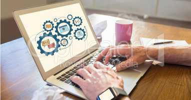 Businessman using laptop with gears displayed on screen