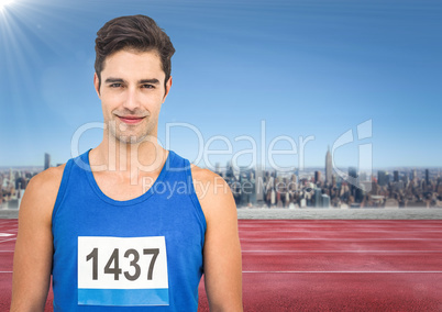 Male runner with number on shirt on track against skyline