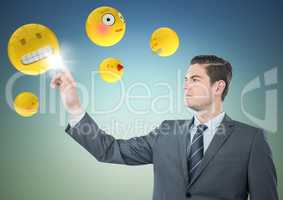 Business man pointing at emojis against blue green background