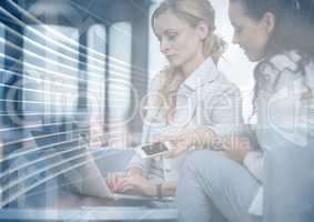 Business women with phone and laptop behind blue arrow graphic overlay