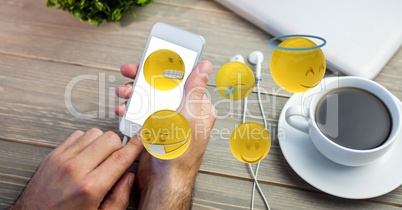 Cropped image of man using smart phone with various emojis