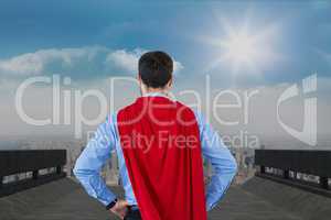 Rear view of businessman wearing cape while standing against sky