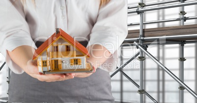woman giving a house in front of 3D scaffolding