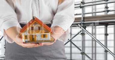 woman giving a house in front of 3D scaffolding