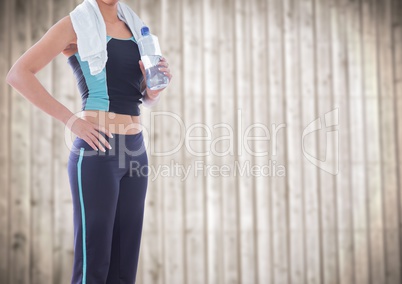 Woman in gym clothes against blurry wood panel