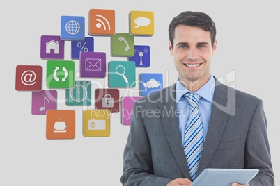 Businessman holding digital tablet with various app icons in background