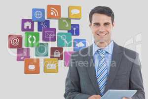Businessman holding digital tablet with various app icons in background