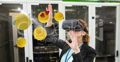 Businesswoman touching various emojis seen through VR glasses in office