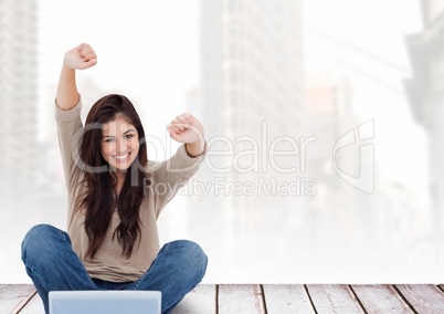 Woman with laptop celebrating success against cityscape