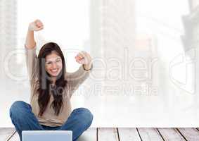 Woman with laptop celebrating success against cityscape