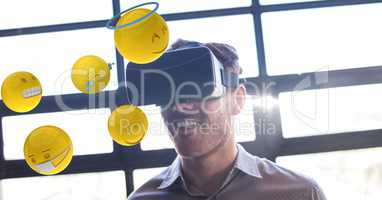 Businessman looking at emojis through VR glasses