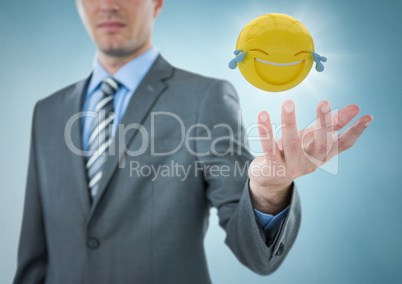 Business man with hand out and emoji with flare against blue background