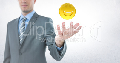 Business man with hand out and emoji with flare against white background