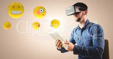 Man in VR using tablet with emojis and flare against cream background