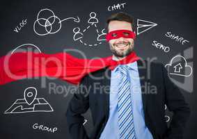 Business man superhero with hands on hips against navy chalkboard with white business doodles