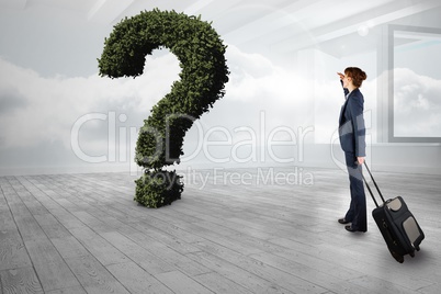 Businesswoman with bag looking at question mark made of plants