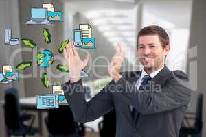 Digitally generated image of businessman gesturing with various icons while working in office