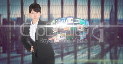 Digital composite image of businesswoman standing at  futuristic desk