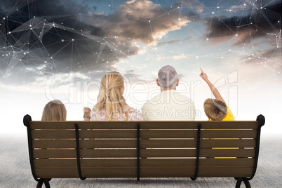 Rear view of family sitting on bench against star constellations