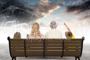 Rear view of family sitting on bench against star constellations