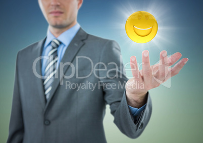 Business man with hand out and emoji with flare against blue green background
