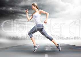 Female runner going across road with skyline and storm