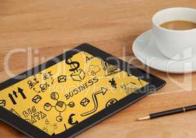 Tablet on table with coffee showing black business doodles and yellow background