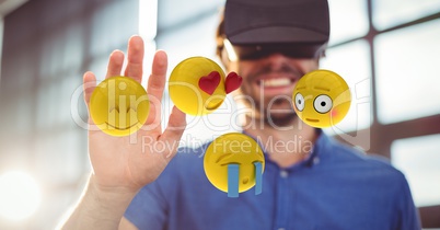 Man looking at emojis through VR glasses