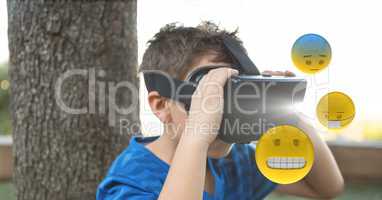 Boy looking at emojis through VR glasses