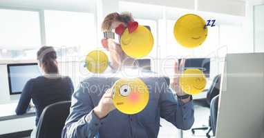 Businessman using VR while touching various emojis