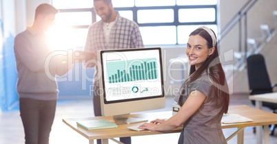 Businesswoman working on graph while colleagues communicating in office