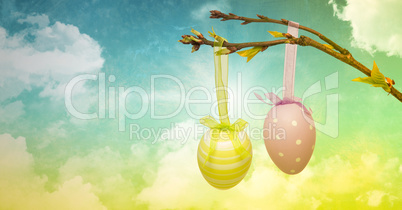 Easter eggs on branch in front of cloudy sky