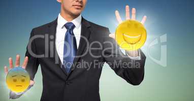 Business man mid section with flares and emojis on hands against blue green background