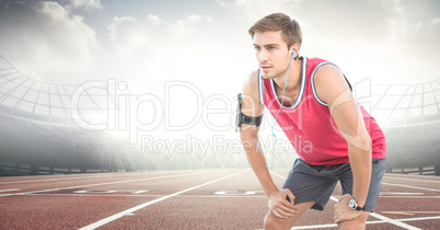 Male runner with headphones on track against flares