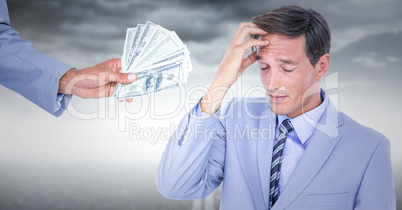 Business man refusing money against stormy sky
